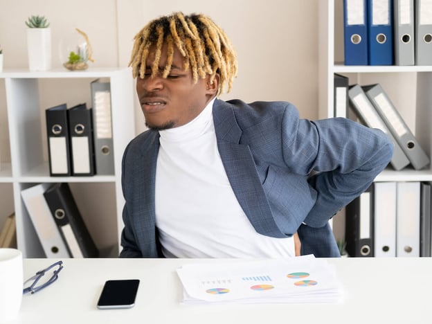 Working conditions: executive holding his back in pain