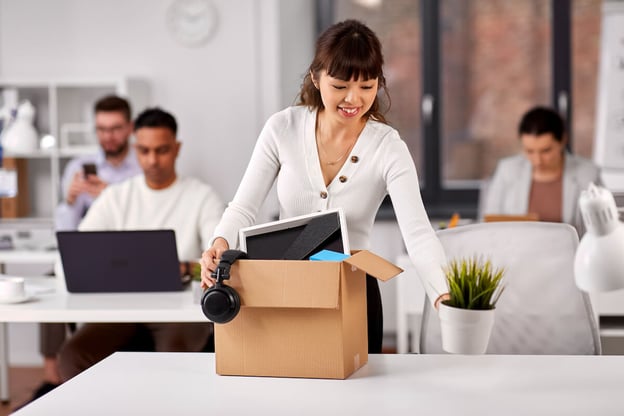 Woman happily clearing out her desk