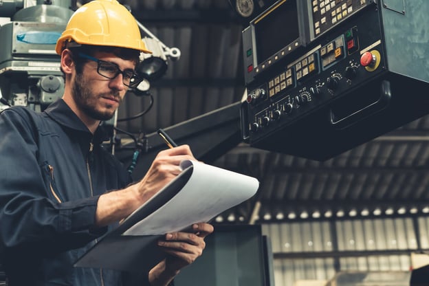 Unsafe working conditions: construction worker writing on a document
