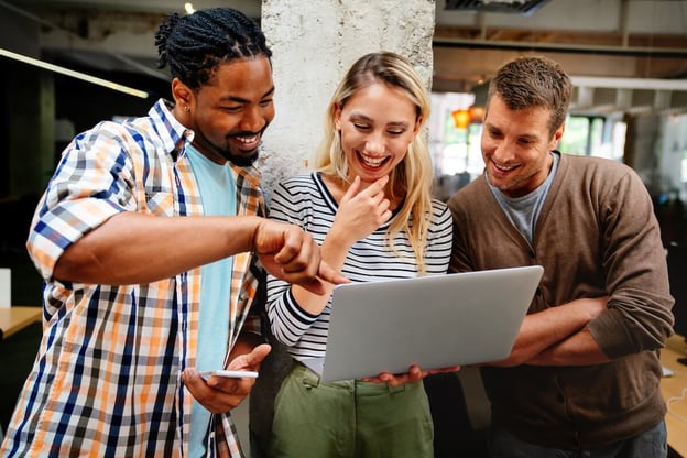 Business process improvement: employees happily looking at a laptop