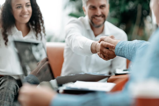 Couple happily shaking hands with an agent