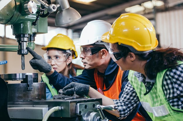Safety training: engineer showing a part of a machine to his team
