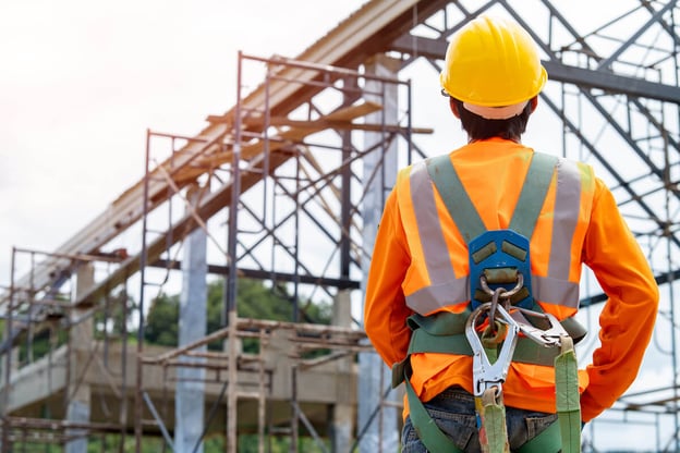 Unsafe working conditions: construction working wearing a harness