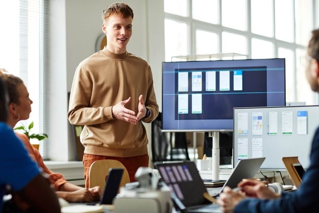 Workplace management: employee presenting something to his colleagues