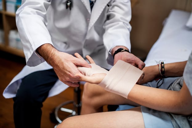 Doctor wrapping a patient's wrist and hand