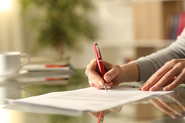 Close-up of a hand signing a contract