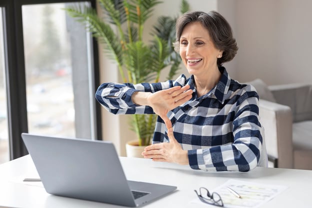 Senior communicating using sign language while having a video call