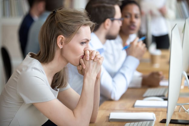 Woman in deep thought, with her hands interlaced over her mouth