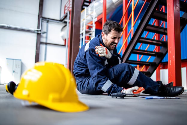 Claim workers compensation: man sitting on the floor screaming in pain