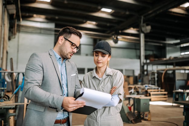 Claims processing: 2 professionals discussing something while at a warehouse