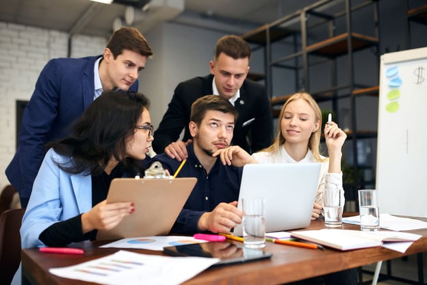 Claims management solutions: team brainstorming while looking at a laptop
