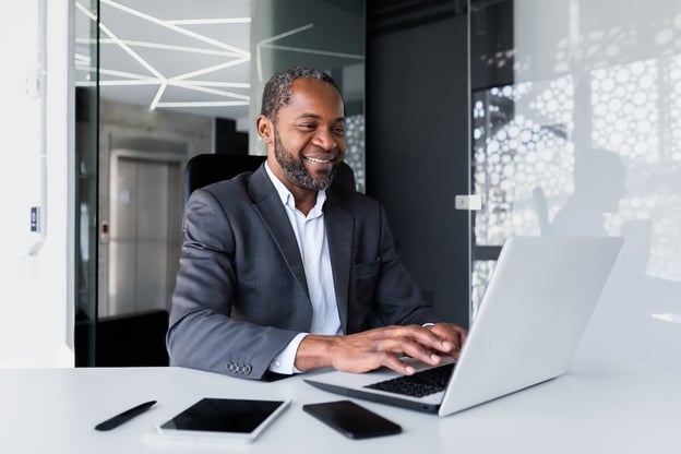 Manager happily using a laptop