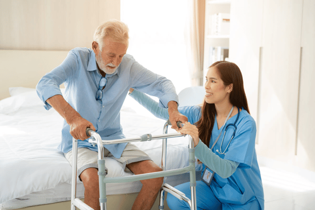 Nurse helping an elderly patient stand-up