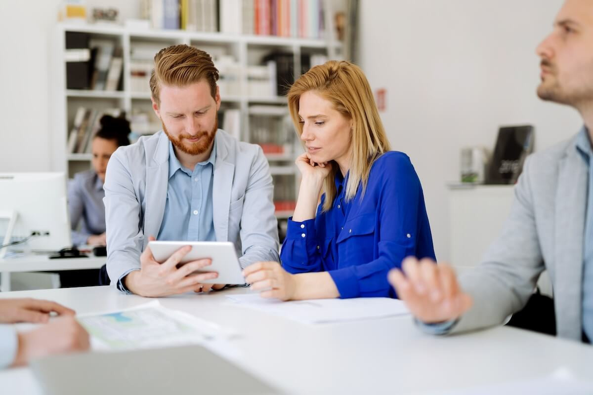 HR tech solutions for brokers: colleagues looking at a tablet