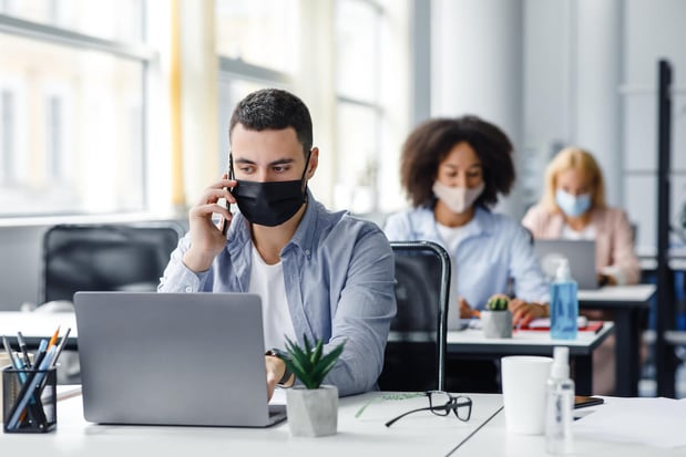 Return to work: people wearing masks while working in an office