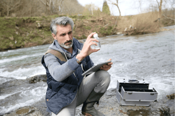 Man inspecting water in a bottle for an environment, health, and safety audit