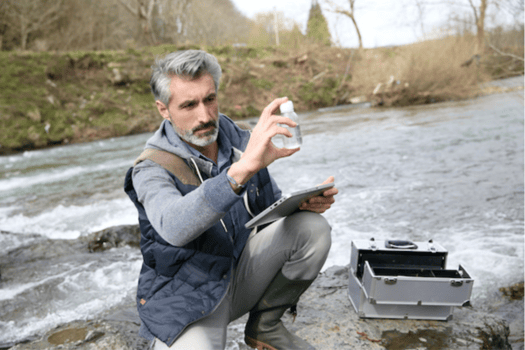 Man inspecting water in a bottle for an environment, health, and safety audit