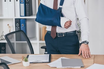 Return to work program: man with a broken arm in his office