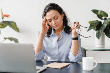 FMLA Ohio: woman with a headache massaging her head