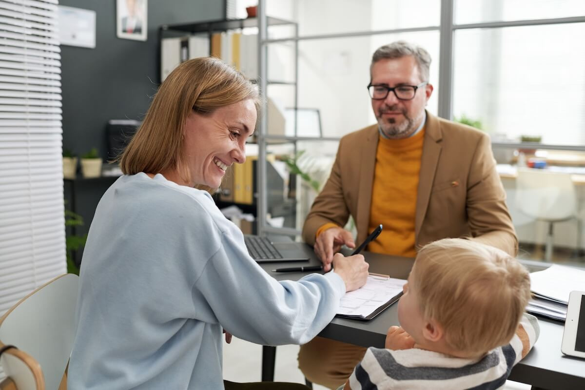 FMLA Minnesota: employee signing a document while looking at her baby
