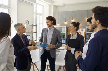 Performance improvement process: group of colleagues standing and talking at their office