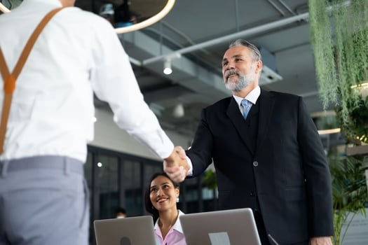 Managing employee relationships: manager shaking hands with an employee