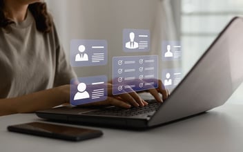 Best leave management software: entrepreneur using a laptop with a holographic dashboard showing user profile icons and a checklist