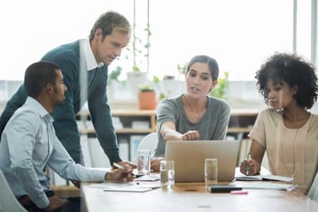 Employee relations tracker: team discussing something while looking at a laptop