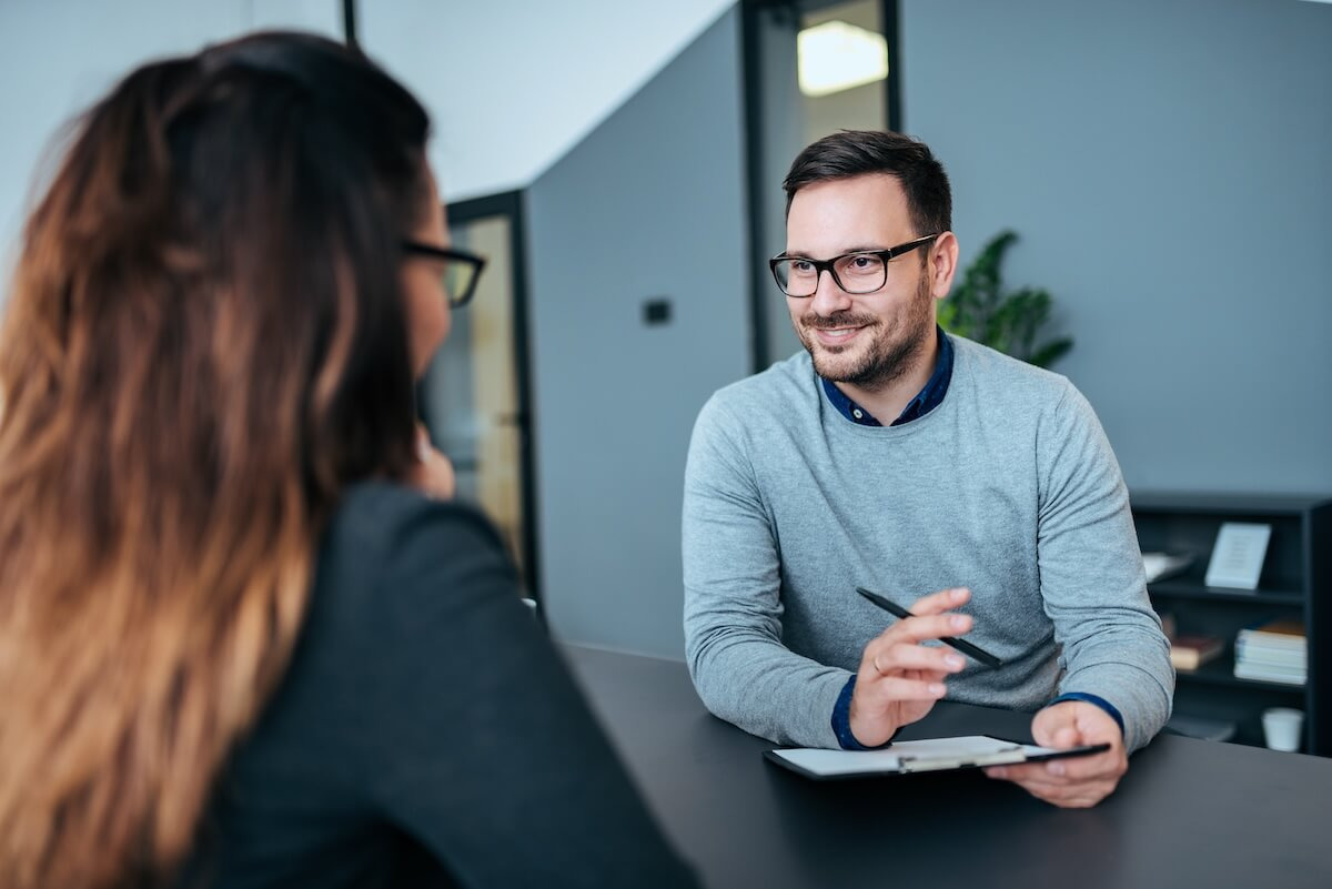 HR employee wearing a pair of eyeglasses, talking to an employee