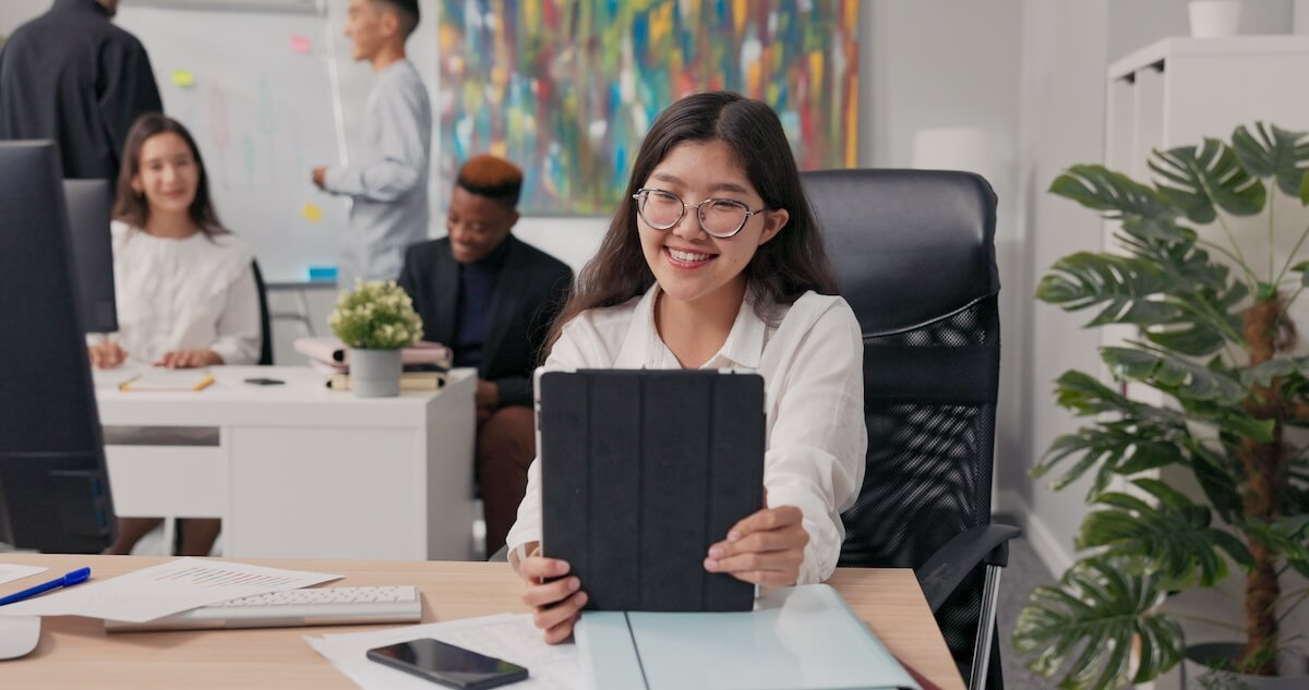 Employee wearing a pair of eyeglasses, using a tablet