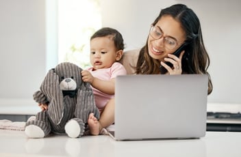 FMLA Nebraska: employee talking on the phone while taking care of her baby