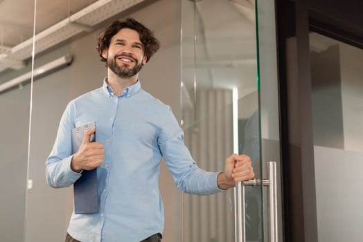 Progressive discipline process: entrepreneur holding a clipboard while opening a glass door