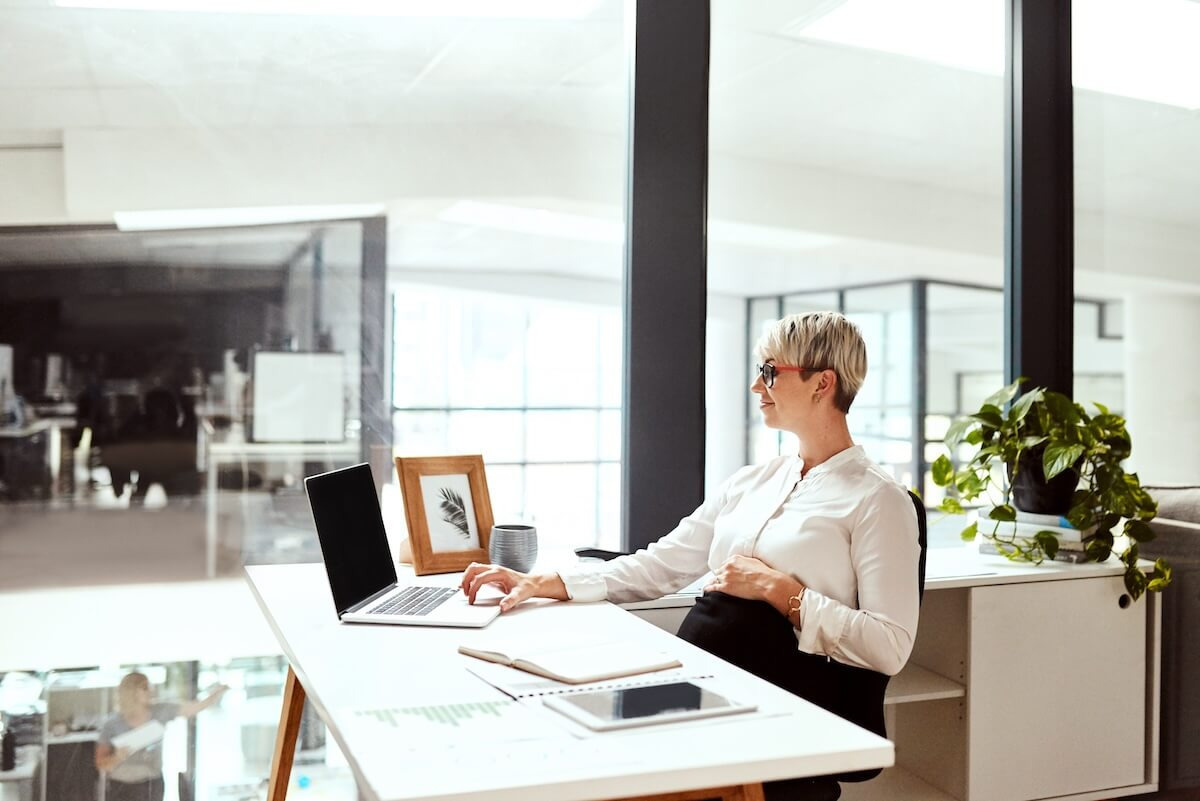 Pregnant entrepreneur using a laptop while holding her belly