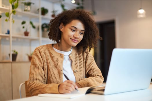 Manager writing employee onboarding automation process in her notebook